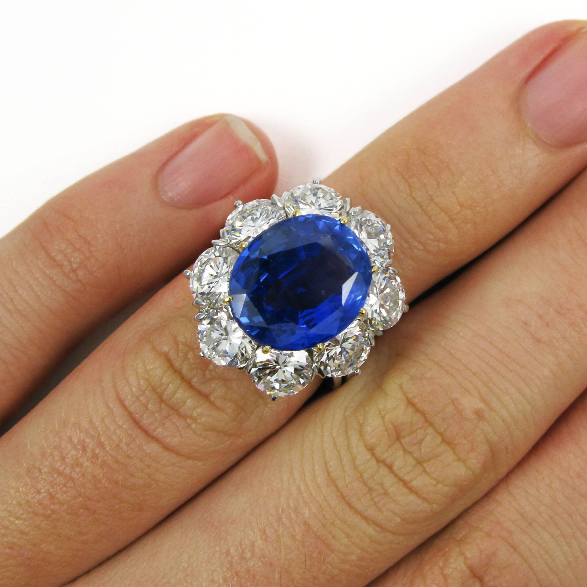 An important and lovely piece, this platinum ring features a vibrant 7.28 carat oval sapphire prong set in yellow gold and surrounded by eight round brilliant-cut diamonds totaling approx. 4.85 carats atop a thin white gold split ring shank.