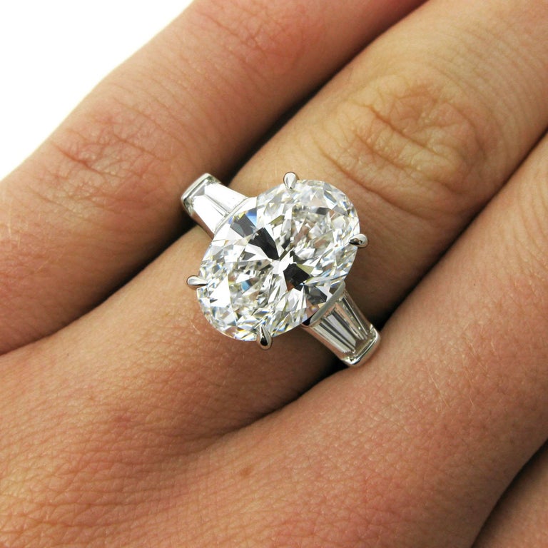 A truly stunning ring from premier American jeweler Tiffany & Co. This ring centers on a 5.13 carat oval cut diamond with D color and VS2 clarity. This center stone is prong-set and flanked by two tapered baguettes in a classic design. Mounted in