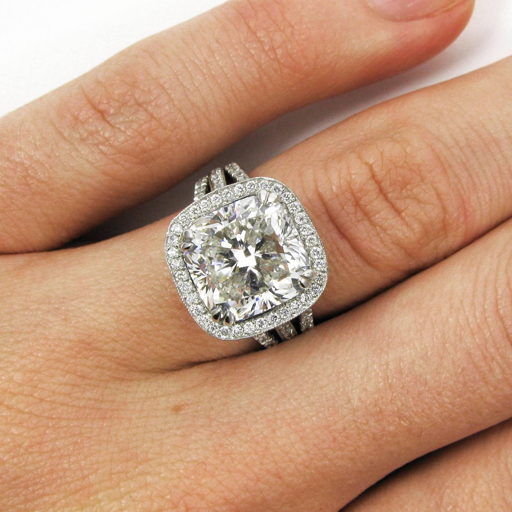 This intricate and stylish design is sure to make an impact! A lovely 6.19 carat cushion-cut diamond with J color and SI1 clarity is prong-set into a triple shank frame ring studded with sparkling pave diamonds. Mounted in platinum. 

Purchase