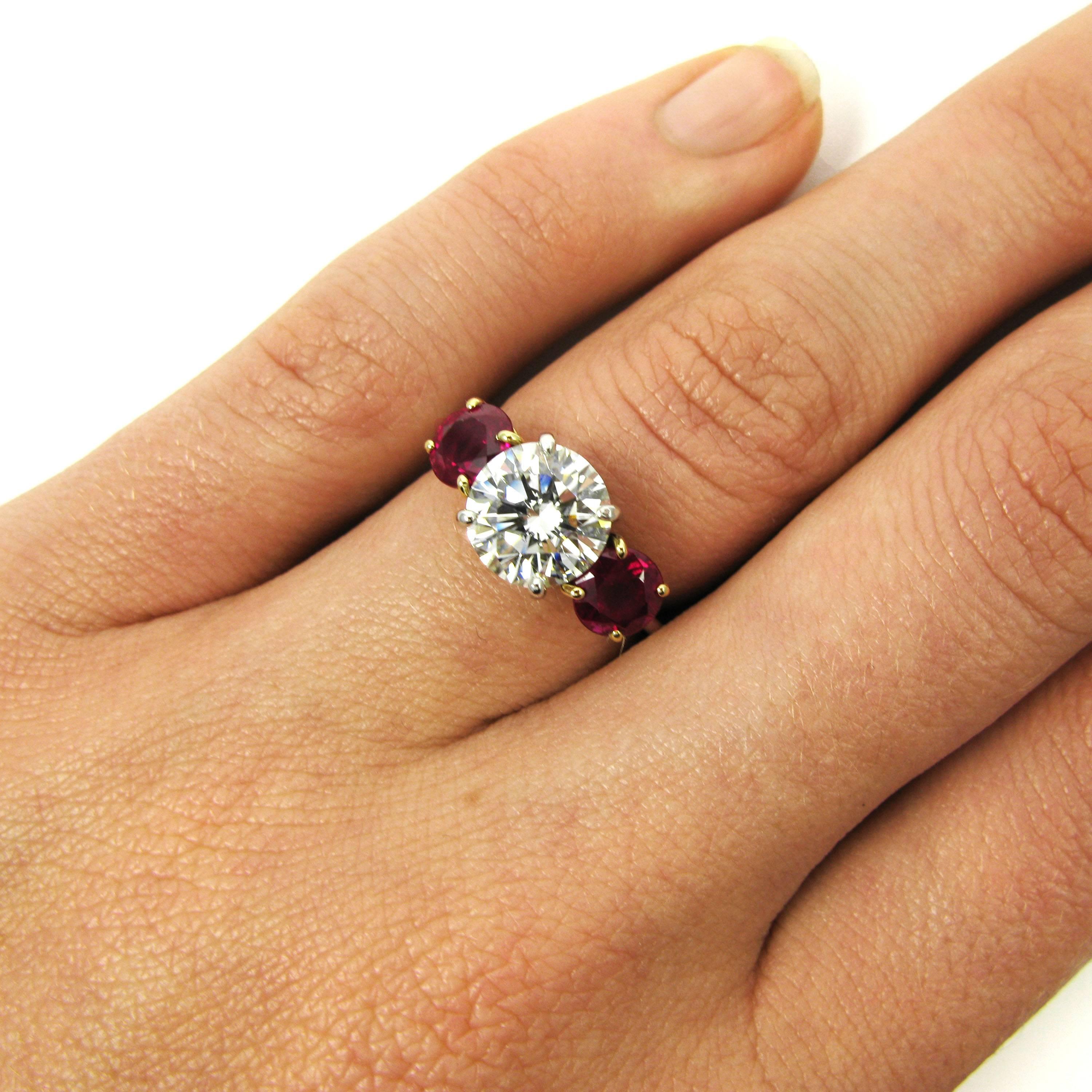 A 2.10 carat round brilliant-cut diamond I color and VS1 clarity is flanked by 2 round-cut rubies in this lovely Tiffany signed ring. Mounted in platinum and 18k yellow gold. 

Purchase includes complimentary sizing, original GIA Certificate and