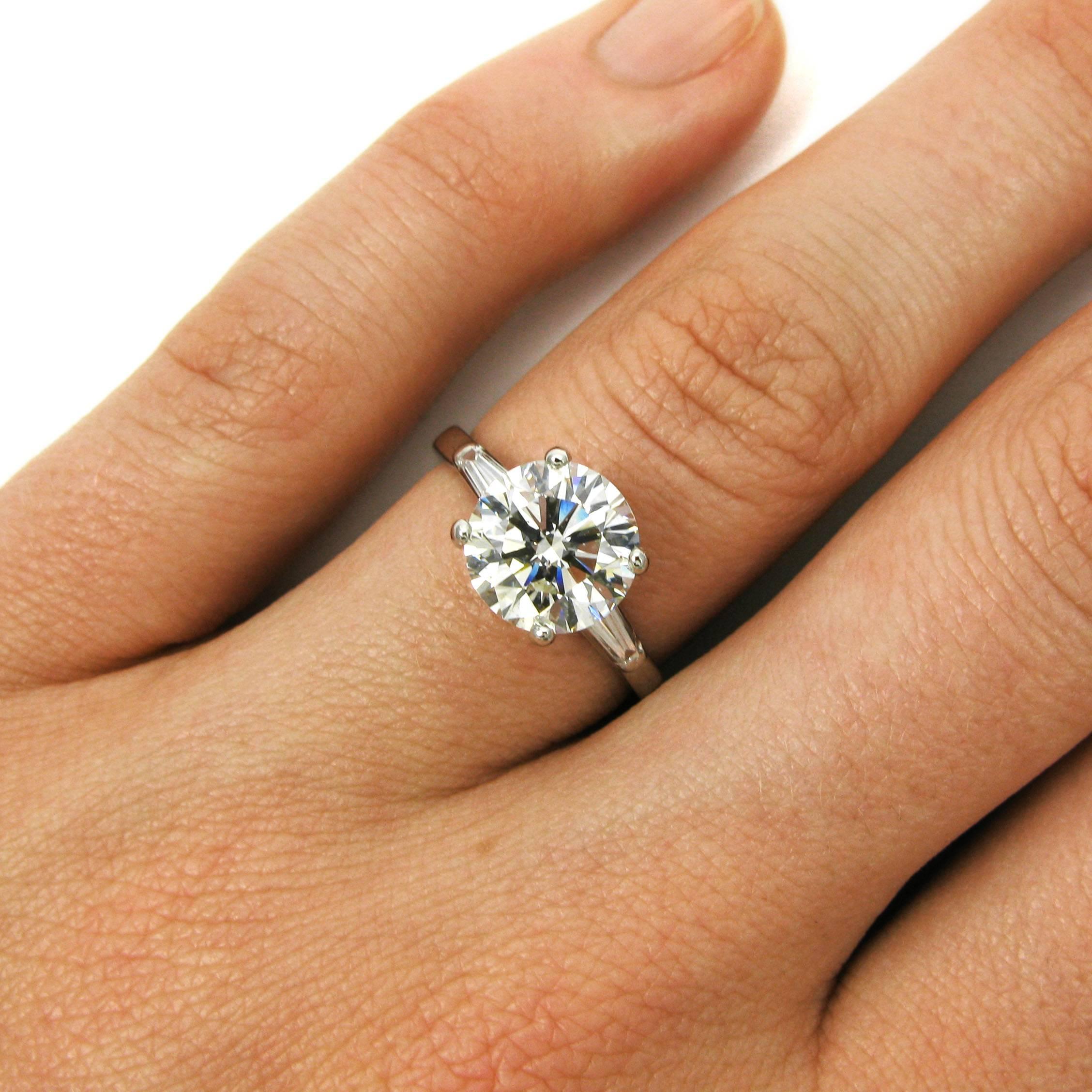 A vintage diamond ring by American jeweler Tiffany & Co. This classic ring features a 2.50 carat round brilliant-cut diamond with H color and VVS2 clarity flanked by two tapered baguette-cut diamonds totaling approx. 0.40 carat. Mounted in platinum,