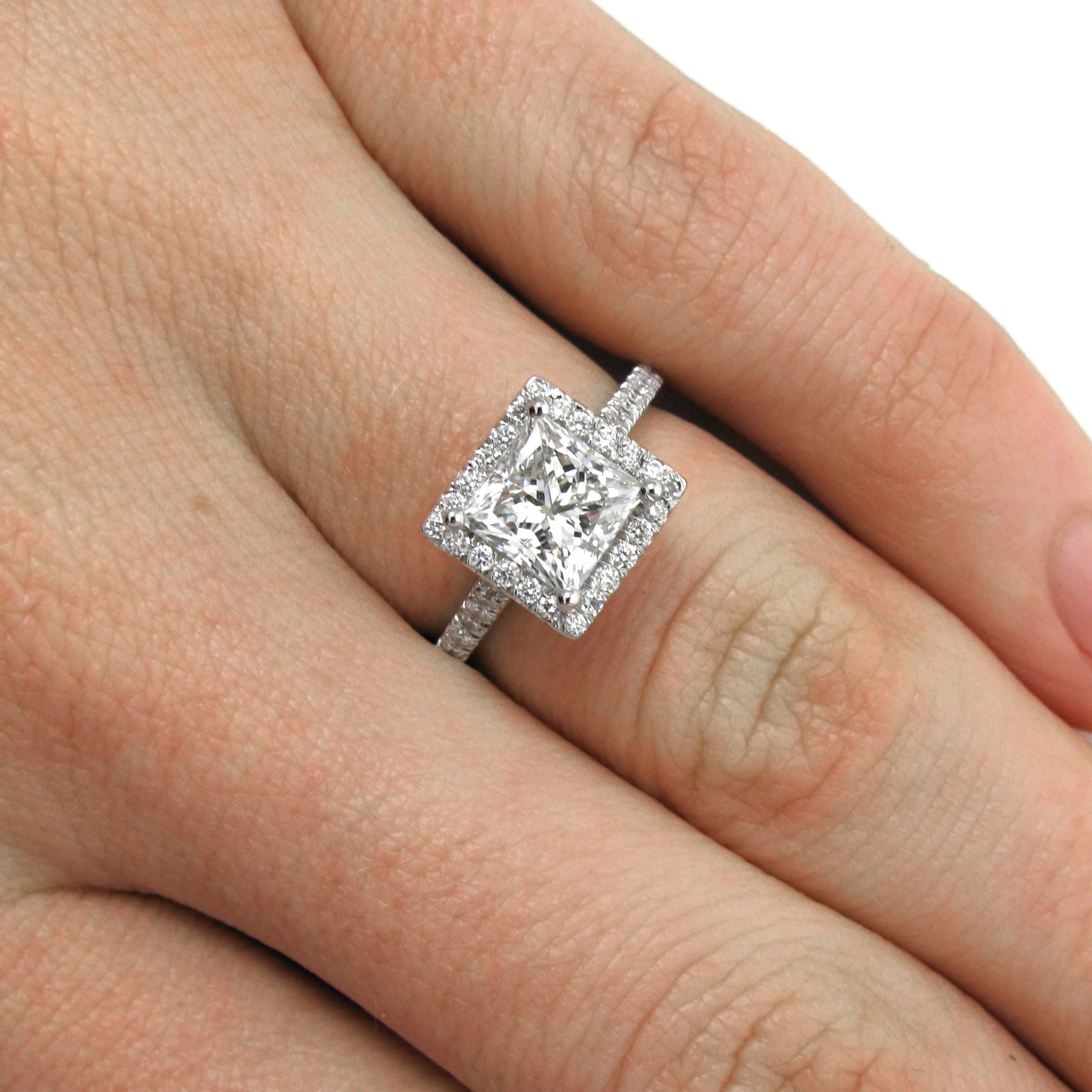 A sparkling 1.50 carat princess-cut diamond with H color and SI2 clarity is prong-set into a platinum frame mounting with high cathedral shoulders. The mounting is accented with approx. 0.50 carat of pave round brilliant-cut diamonds. 

Purchase