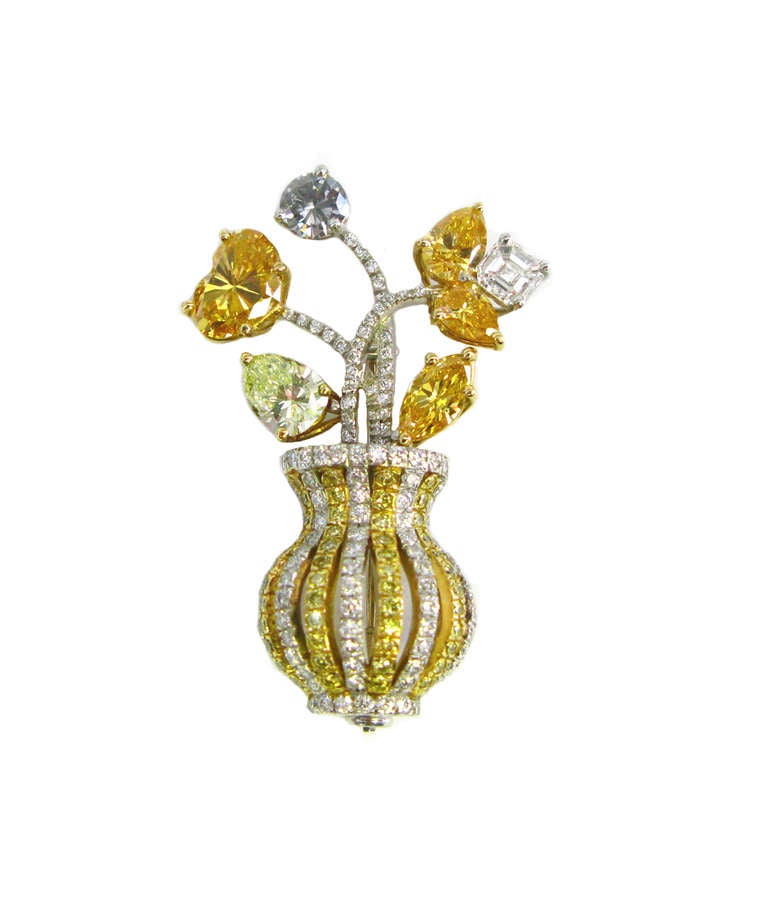 This whimsical floral design pin features natural colorless and fancy colored diamonds set in platinum and 18kt yellow gold. This lovely pin showcases fancy yellow, orange, and gray fancy shape diamonds in a colorless and fancy yellow diamond pave