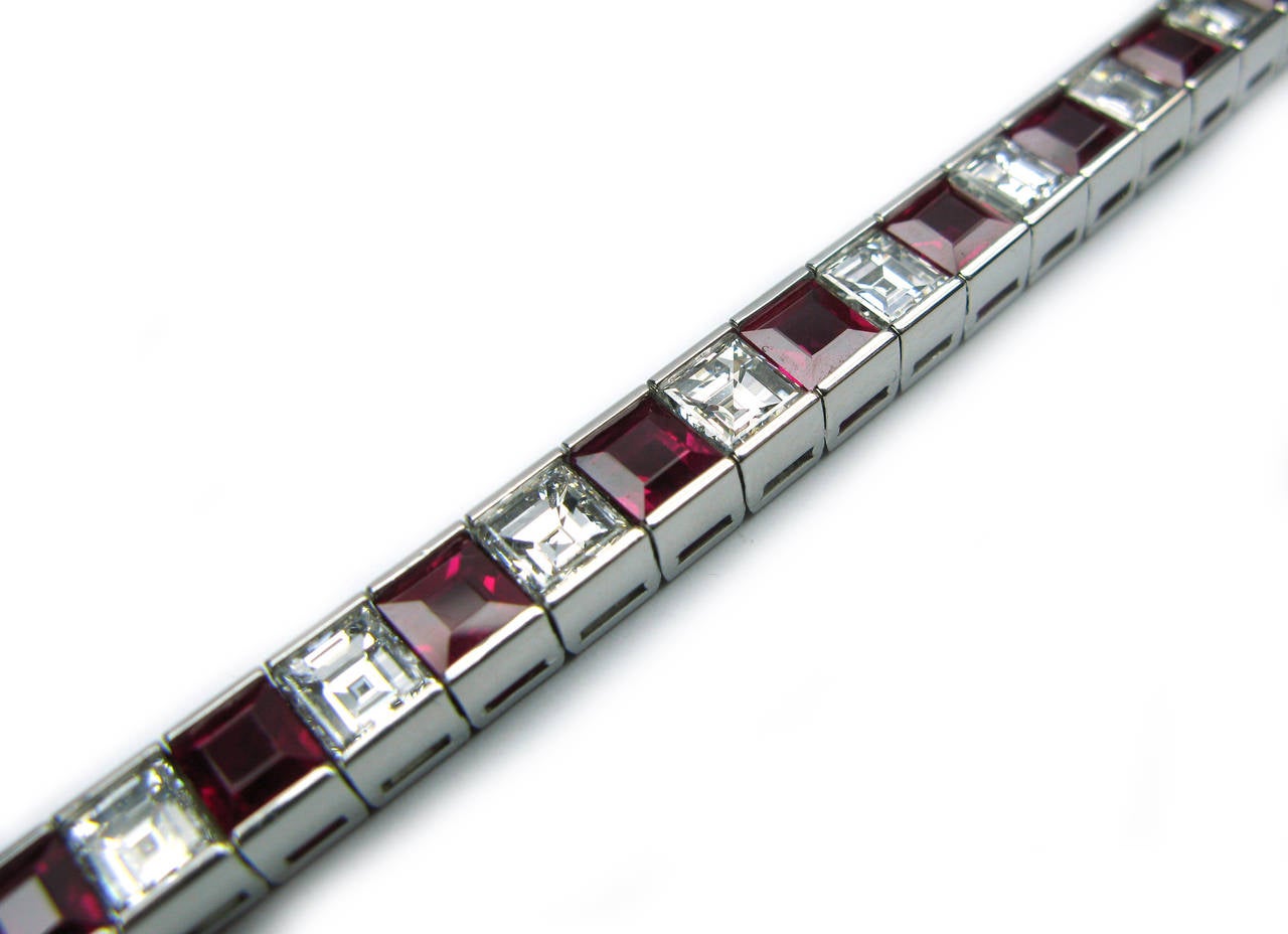 This beautiful platinum channel set single row bracelet contains 19 E color, VS clarity, Asscher cut diamonds weighing 9.91ctw alternating with 19 richly colored step cut rubies weighing 12.01ctw. A classic piece to add to your collection!