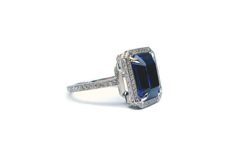 This vivid blue emerald cut 7.65 carat sapphire ring is set in platinum and 18kt gold. It sits in a pave setting that brings out the intensity of the center stone. Wear it as a new spin on the classic engagement ring or throw it on as a cocktail