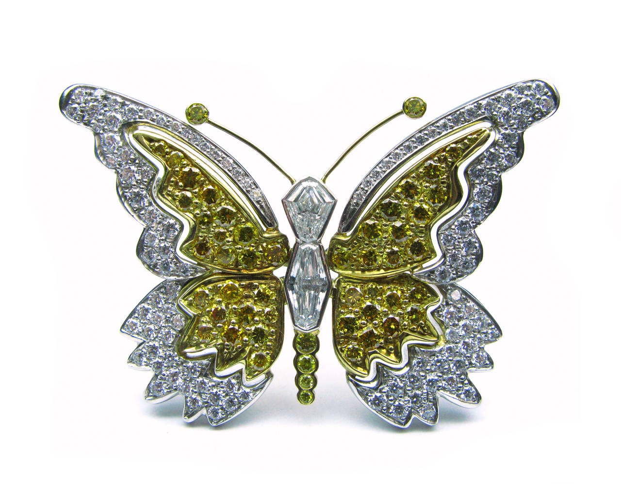 This gorgeous yellow and white diamond butterfly pin, set in platinum and 18kt yellow gold, is a super way to add sparkle to your outfit. It contains 6.78 carats of  E color diamonds and natural fancy intense yellow color diamonds in VS1 clarity. A