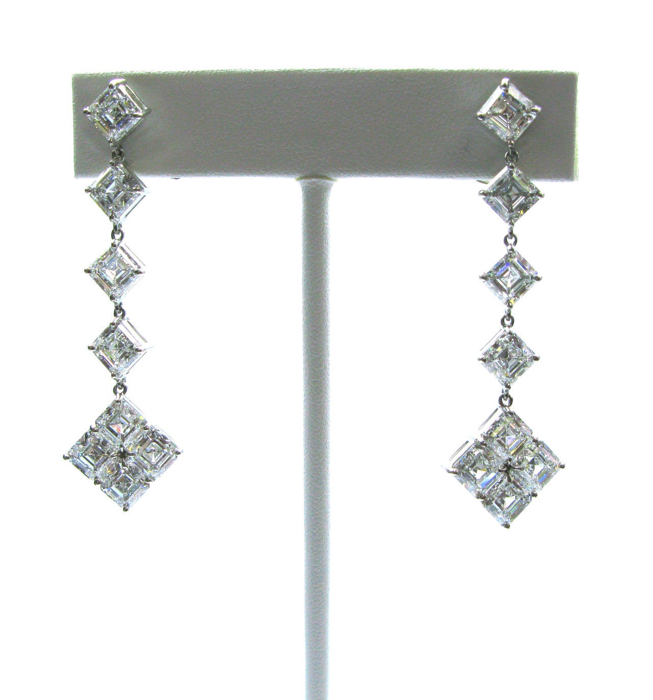 This spectacular pair of platinum earrings contains 16 GIA certified Asscher cut diamonds ranging in quality from D-F color and IF-VVS clarity. 

Each earring has a four diamond drop with a four diamond cluster at the bottom. These stunning earrings