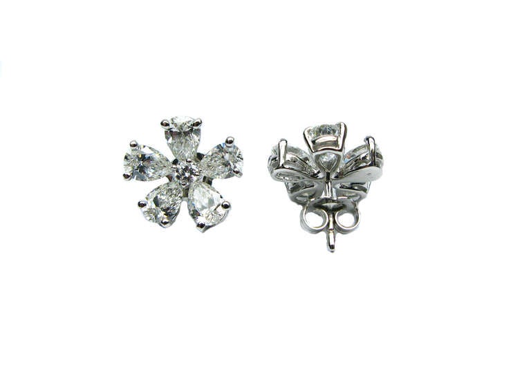 These gorgeous 3.11ctw, G/H color, VS1 clarity, flower patterned diamond cluster earrings are set in 18 karat white gold and feature a total of 10 pear shaped diamonds with one round brilliant diamond at the center of each stud. This flirty design