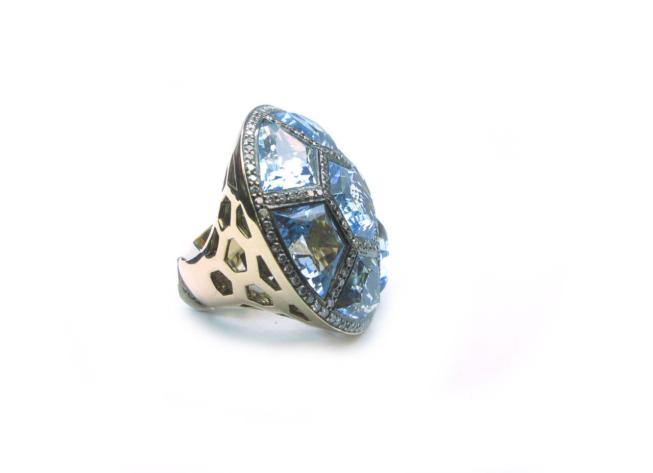 For more than 40 years, the name Zorab has been synonymous with beautiful jewelry that is both playful and sophisticated. This stunning Zorab signed 18kt rose gold cocktail ring features a faceted hexagon blue topaz center stone surrounded by 6