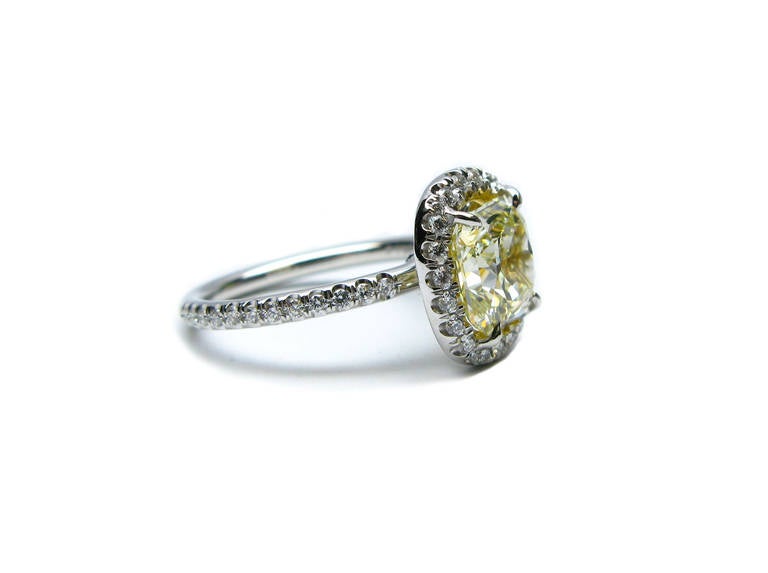 This dazzling 2.39 carat Vs1 clarity radiant cut fancy light yellow diamond is set in platinum and 18Kt yellow gold, with approximately 0.60ctw of pave surrounding the center stone and extending down the band. This piece is a wonderful alternative