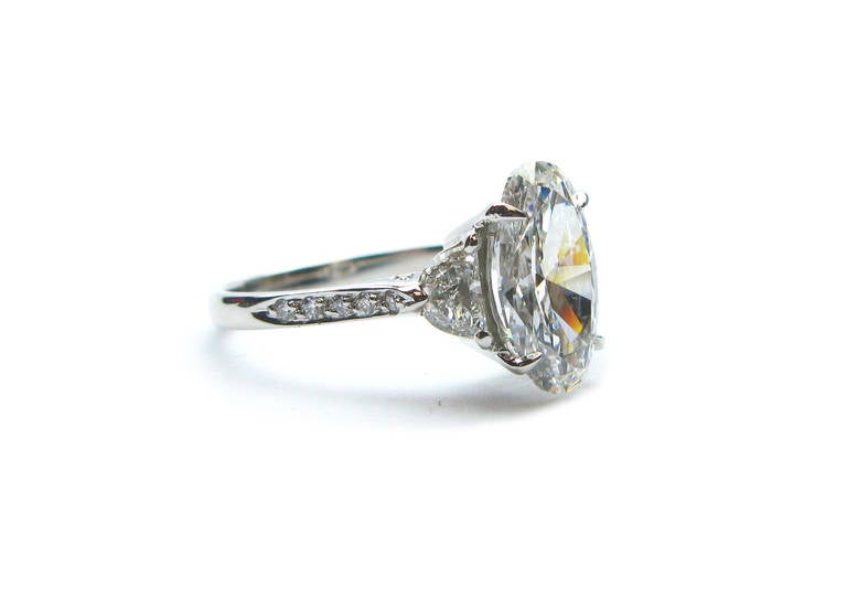 This 2.14Ct GIA certified, F color, VS1 clarity, oval diamond ring is set in platinum with two 0.70ctw half moons on the side of the center stone and a delicate pave shank. This gorgeous ring is the perfect way to start the next chapter of life with