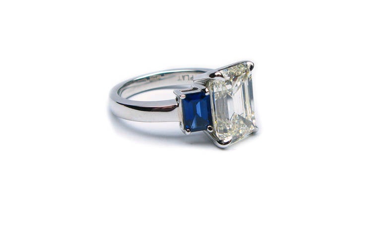 This platinum, three-stone ring features an EGL certified 3.58 carat emerald cut diamond of I color and VS2 clarity as described by EGL grading report #2708321225. Flanked by a pair of beautifully saturated sapphires, this big-looking ring is a