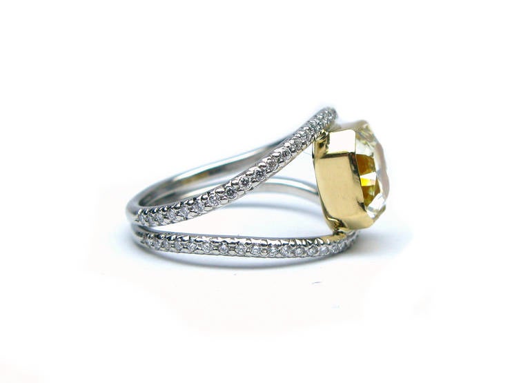 This GIA certified 1.73Ct fancy yellow VVS1 clarity radiant cut diamond is bezel set in 18Kt yellow gold with 0.36ctw of pave on its platinum split band design. This is a modern alternative to the classic engagement ring. Don't let this unique piece