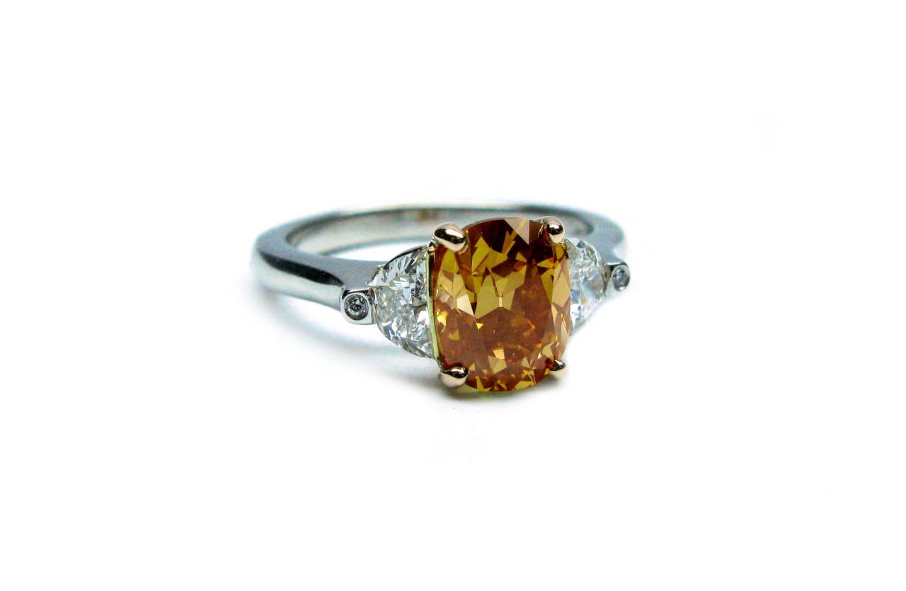 This rich, luxurious color diamond is a rare and elegant piece to add to your collection. Perfect as a sophisticated right hand ring or a unique engagement ring, this ring showcases a 1.57 carat cushion certified by GIA to be Fancy Brownish Orangy