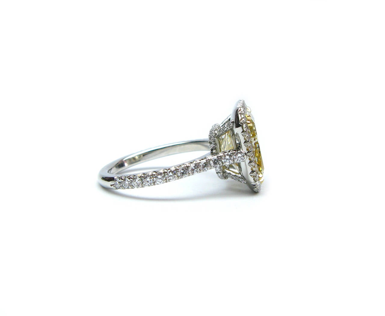 This exquisite GIA certified 5.38Ct fancy light yellow, Si1 clarity radiant cut diamond ring is set in a stunning platinum and 18Kt gold pave frame that extends half way down the band of the ring. The fancy color of the diamond with the modern pave