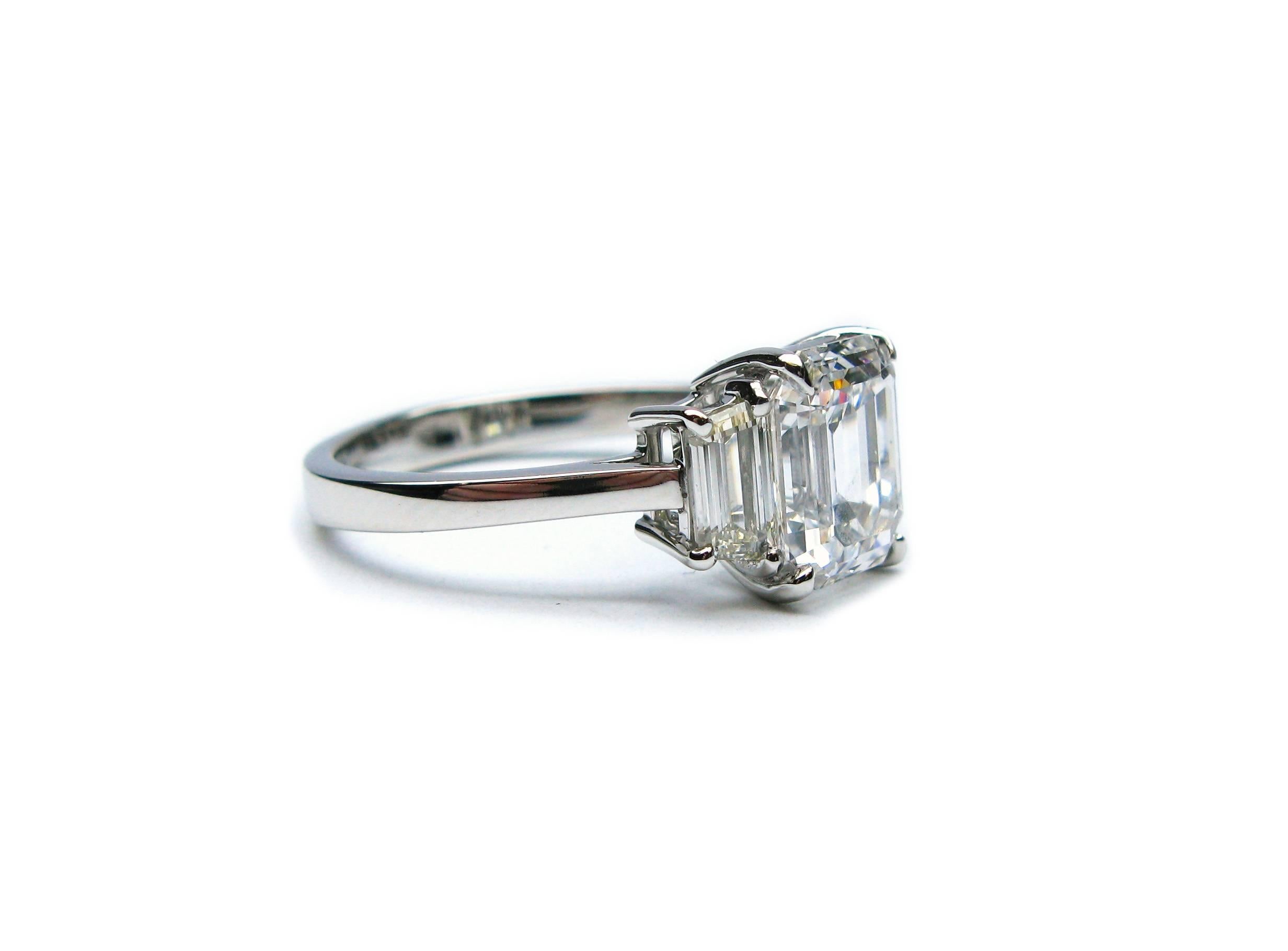 This handmade, platinum ring features a GIA certified 2.06 ct Emerald cut of D color and VS2 clarity... Set with step-cut trapezoid side stones = 0.72 ctw,  this timeless ring is guaranteed to make her say, 