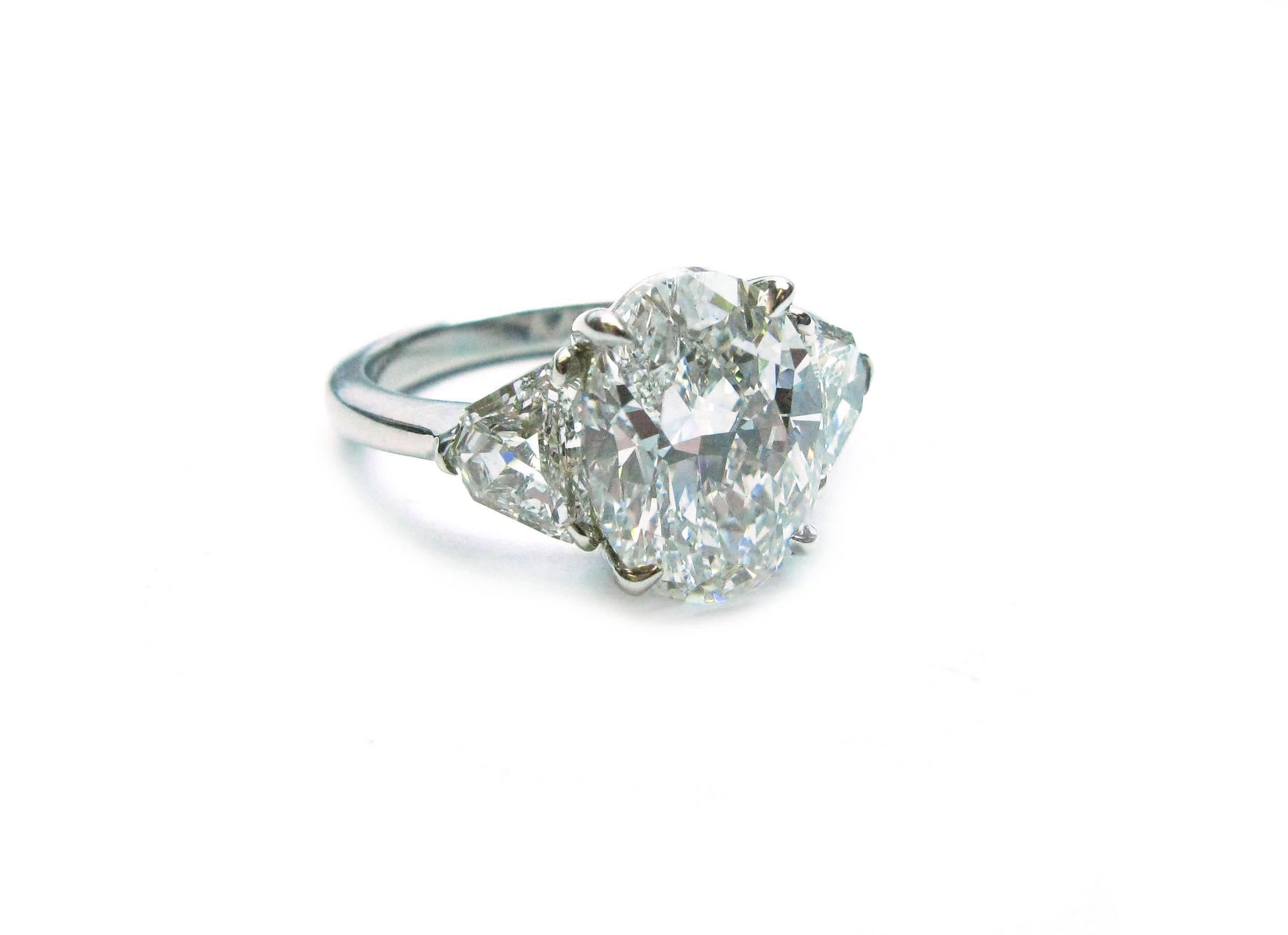 This lovely handmade platinum ring features a GIA certified 3.63ct, G color, VS1 clarity, Oval cut diamond center stone with 0.84ctw shield cut diamond sidestones. This sparkling combination is the perfect choice for an engagement ring!