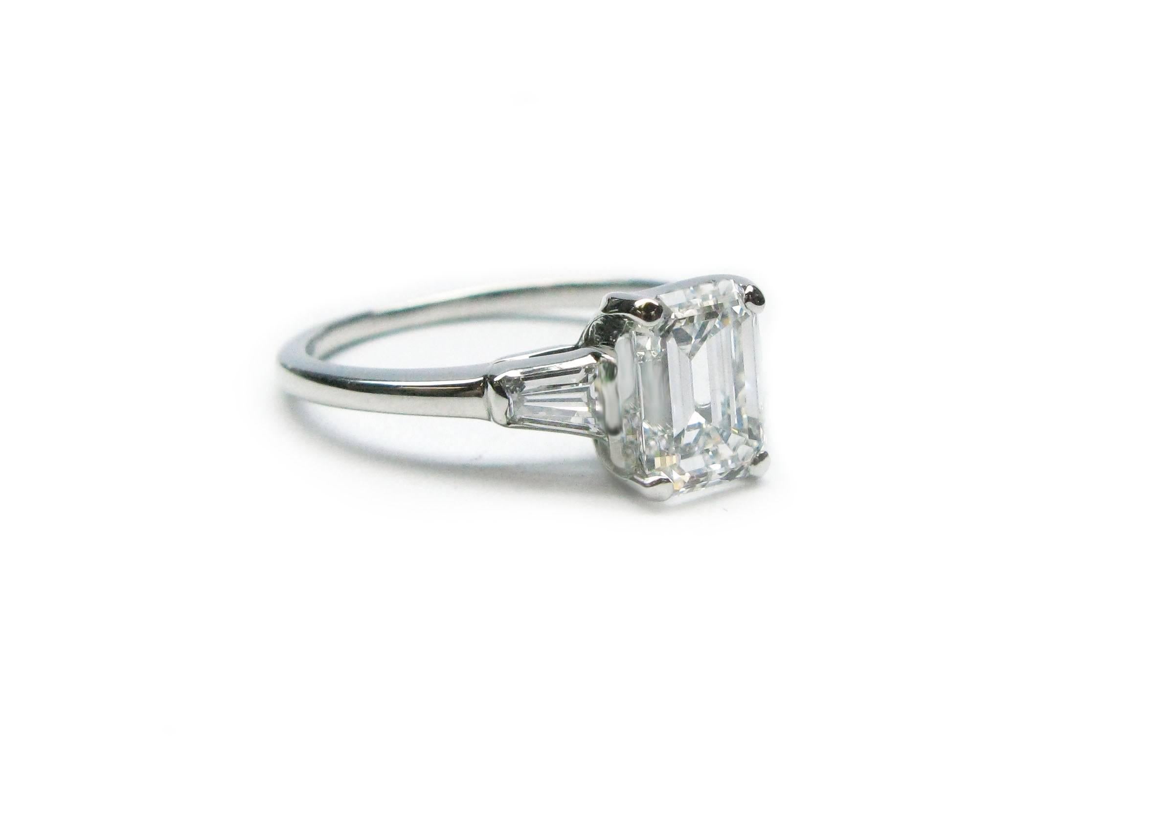 This lovely handmade platinum engagement ring features a GIA certified 1.54ct, E color, SI1 clarity, Emerald cut diamond with approximately 0.40ctw tapered baguette diamond sidestones. This timeless ring is meant for one special girl!