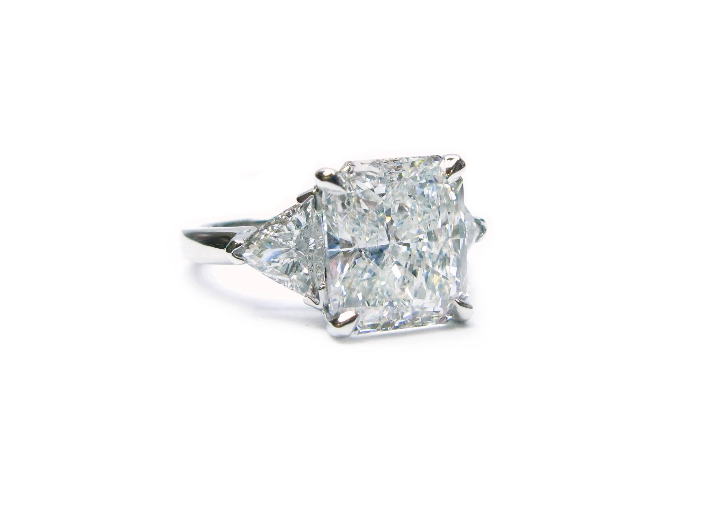 This stunning handmade platinum ring features a GIA certified 5.00ct, G color, SI2 clarity, Radiant cut diamond center stone with approximately 1.30ctw trillion diamond sidestones. This lovely engagement ring will make one lucky lady very happy!