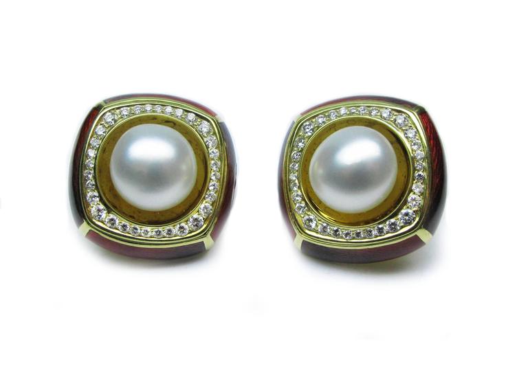 These lovely 18kt yellow gold red enamel De Vroomen signed ear clips feature a mabe pearl center stone with 1.97ctw round brilliant diamond frames. These earrings offer a big look that will never go out of style.