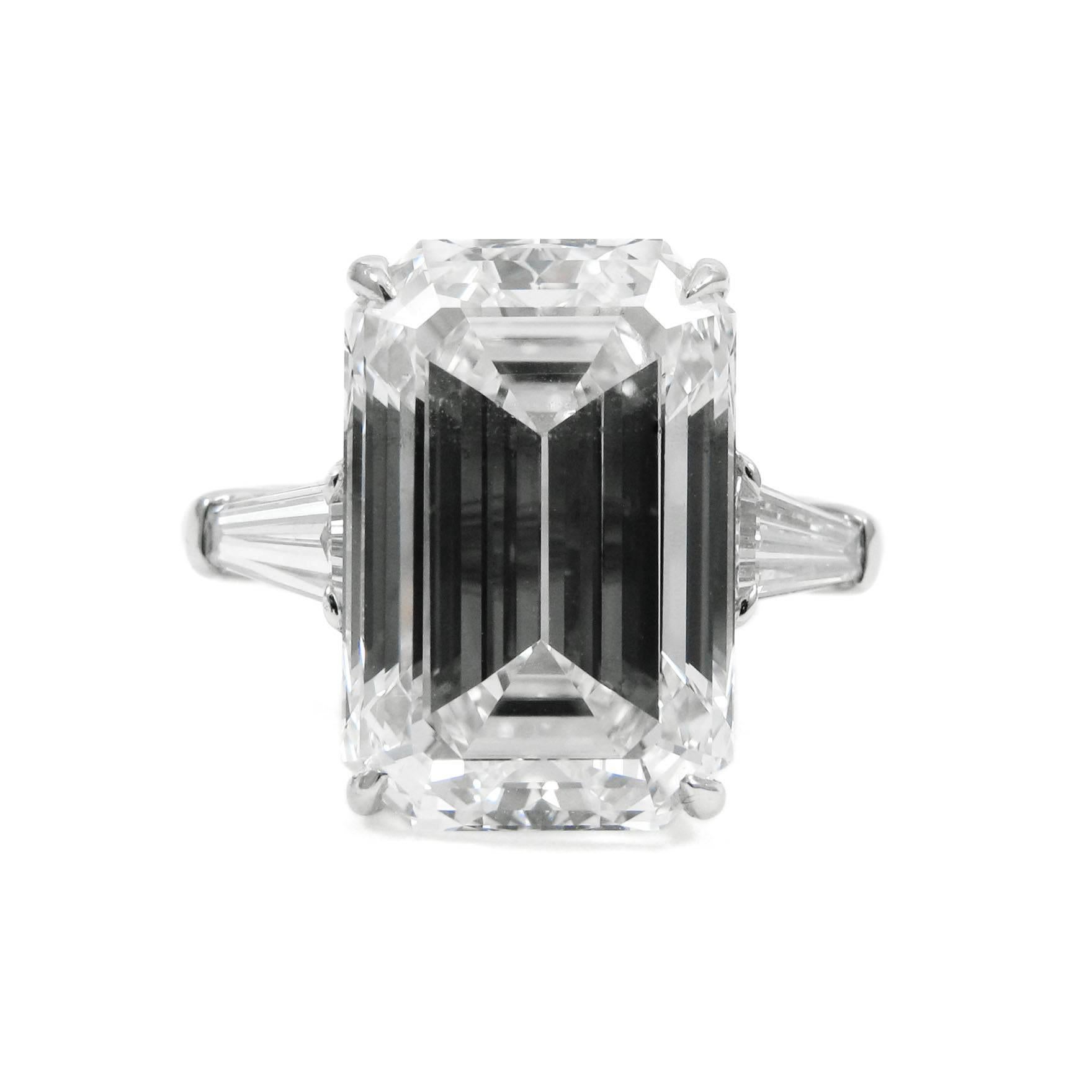 A classic style platinum ring set with a fabulous 8.00 carat emerald cut diamond with F color and SI1 clarity. The diamond is claw-set into a basket setting and flanked by two tapered baguette-cut diamonds totaling 0.64 carats in bar settings. An