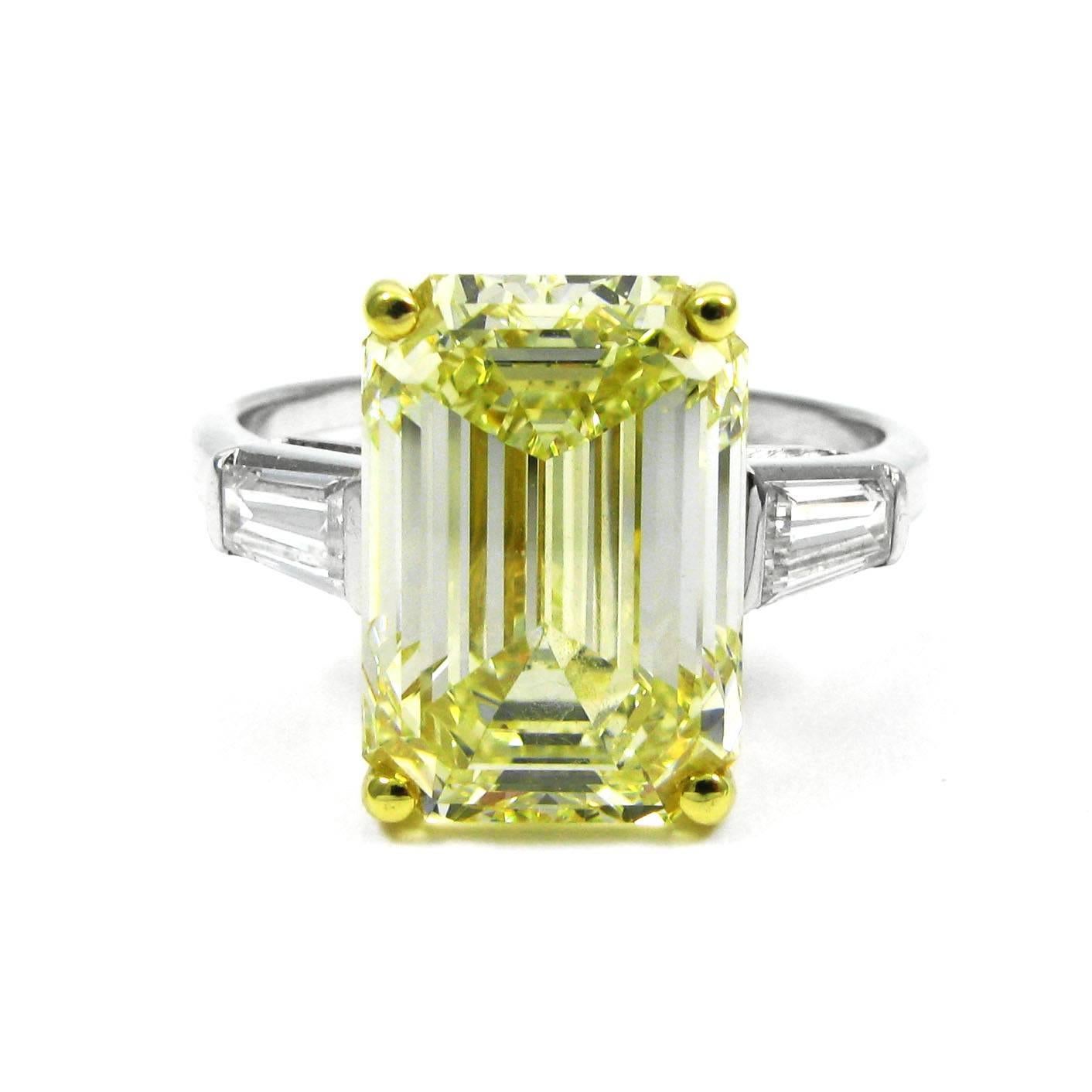 A drop of sunshine! This ring features a cheerful 6.69 carat Fancy Light Yellow emerald-cut diamond set in an 18k yellow gold basket and flanked by two tapered baguette-cut white diamonds totaling approx. 0.85 carat. The stones are mounted in the