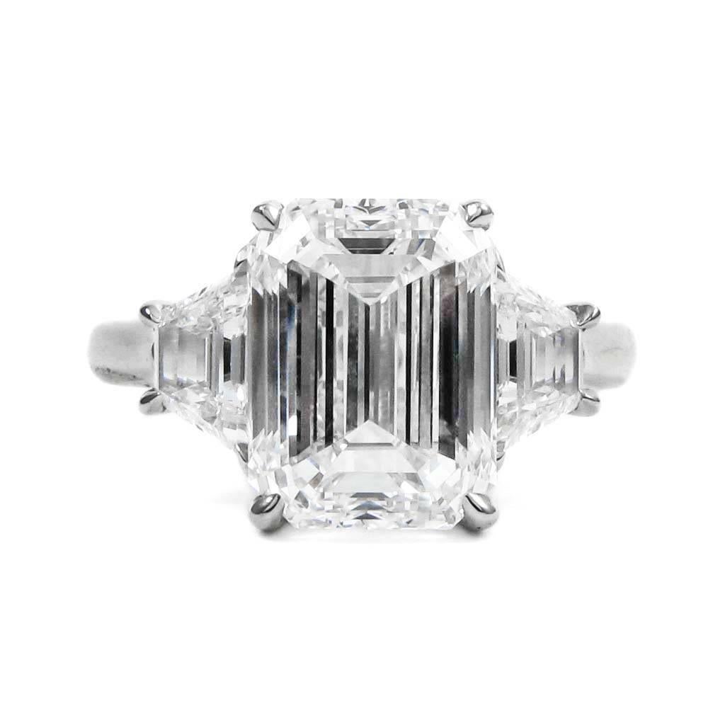 This lovely ring centers on a 4.70 carat emerald-cut diamond with G color and VVS2 clarity, flanked by two matching trapezoid-cut diamonds totaling approx. 0.85 carat. Mounted in platinum. Simply stunning!

Purchase includes GIA Diamond Grading