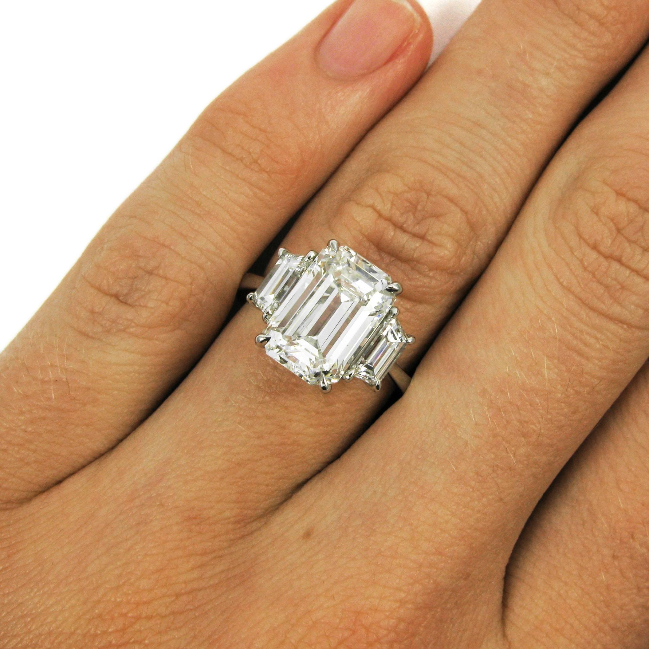 A 4.48 carat emerald-cut diamond with H color and VS2 clarity is set in low claw prongs and flanked by a matched pair of trapezoid-cut diamonds totaling 0.73 carat atop a slim platinum ring shank. 

Purchase includes GIA Diamond Grading Report