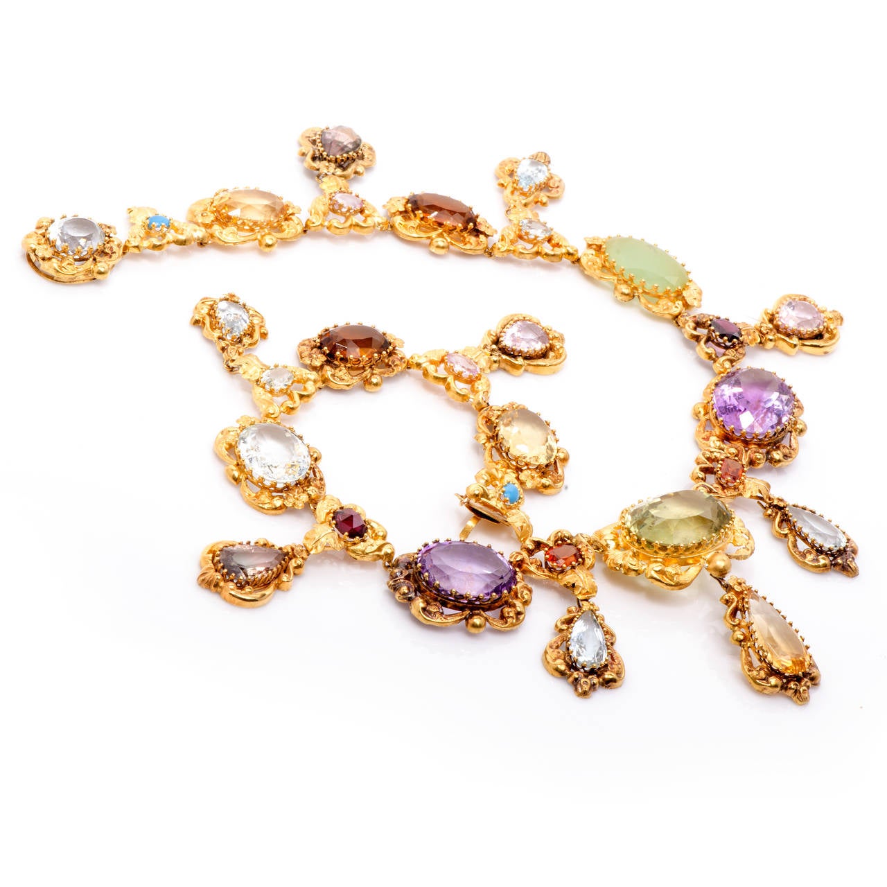 This spectacular antique necklace circa 1700s is crafted in solid 18K yellow gold. Whimsical, colorful and elegant, this gemstone necklace features 27 gemstones (amethyst, peridot, quartz, citrine, jade, aquamarine, rainbow topaz, and tourmaline and