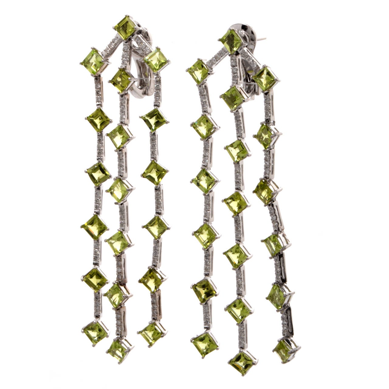 These chandelier earrings with peridot and diamonds are crafted in solid platinum, weighing 30.7 grams and measuring 3