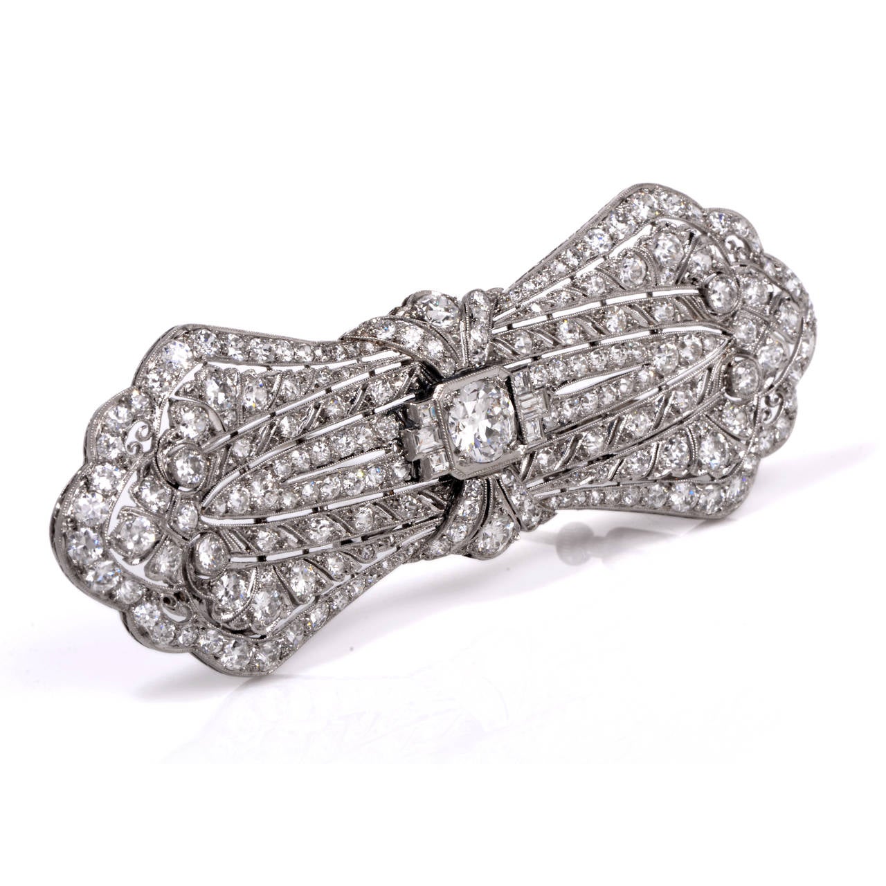 This exquisite Antique diamond pin has a stunning presence that is simply breath-taking. Finely crafted in solid platinum, it is centered with 1 genuine round cut diamond that is surrounded by a magnificent display of diamonds. Its center is holding