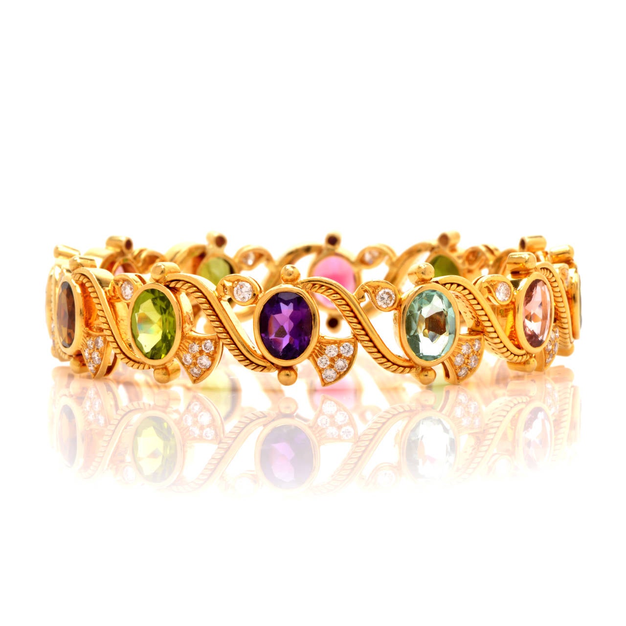 This exquisite multi-gem bangle bracelet of artistic design and immaculate artisanship is handcrafted in solid 18K yellow gold, weighing approx. 54.3 grams and measuring 7.5