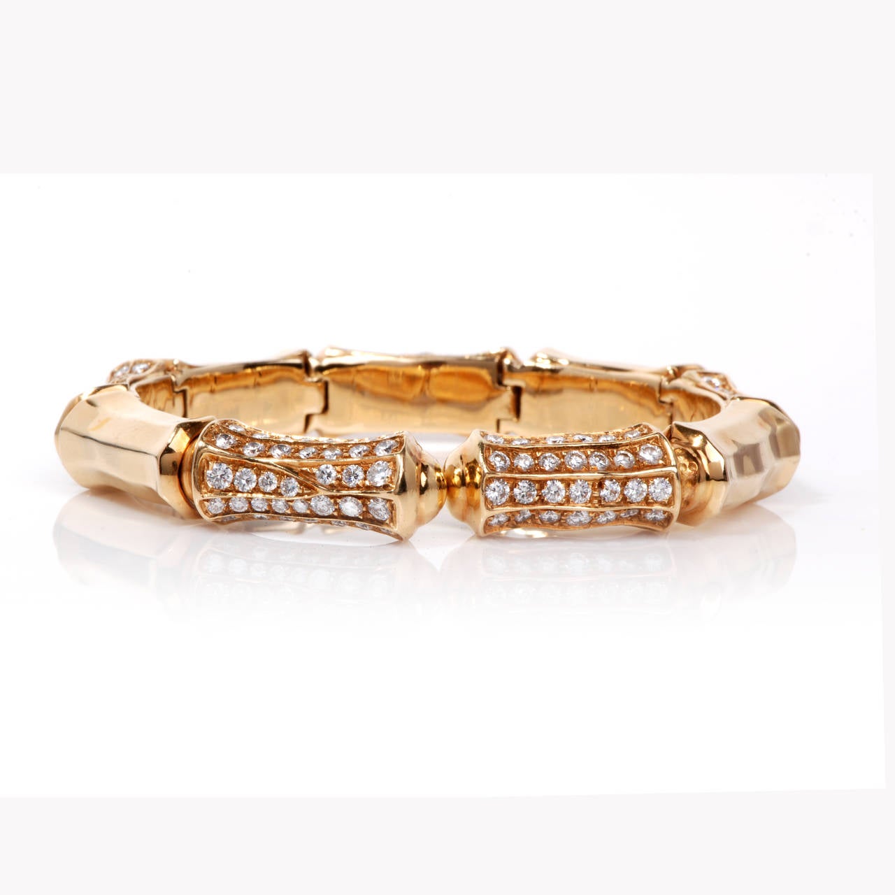 This gorgeous vintage bamboo design link bracelet is crafted in solid 18k yellow gold. The bracelet is accented with some 200 genuine round cut diamonds approx. 11.00ct, F-G color and VS1 clarity. The Bangle cuff bracelet provides a secure clip