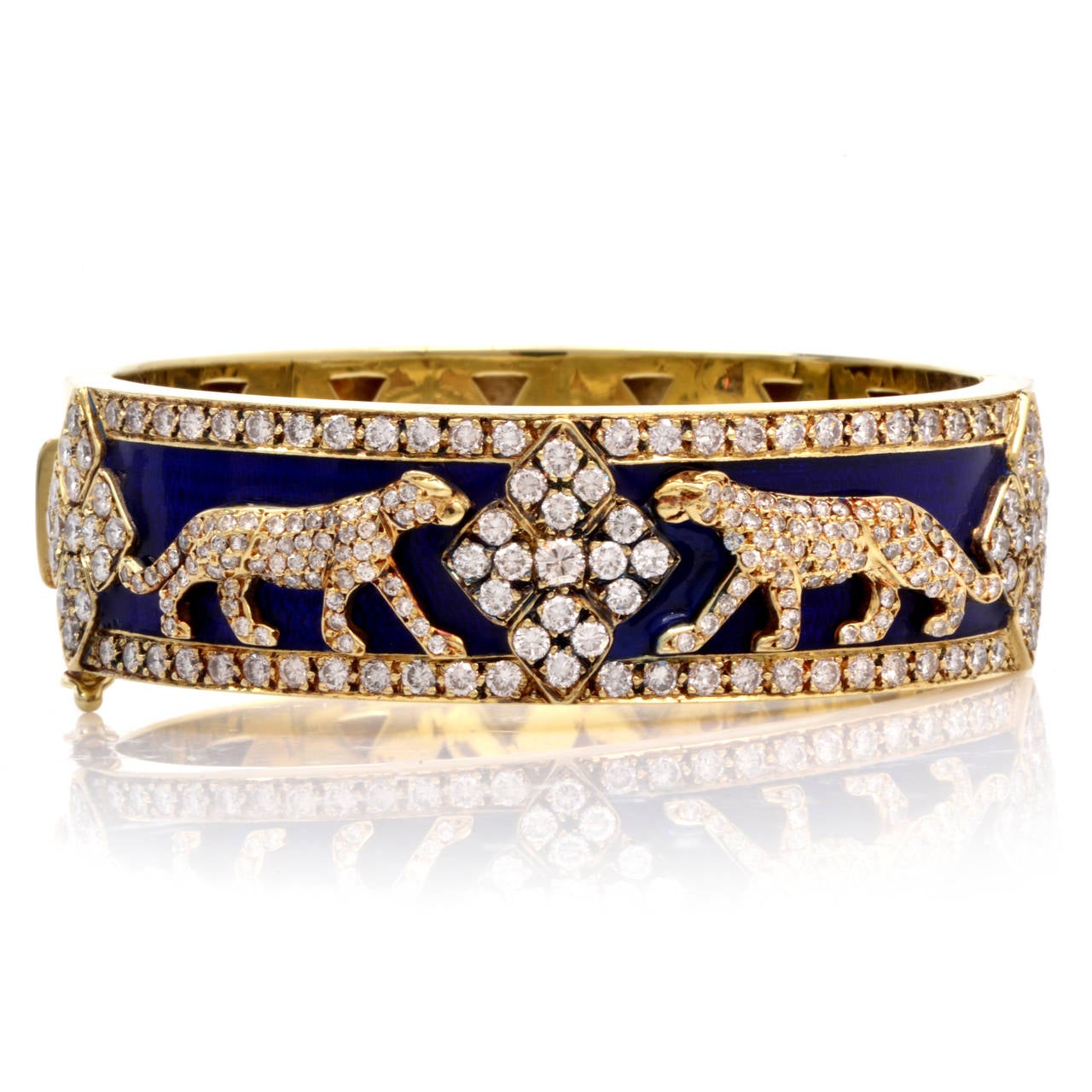 This Vintage 14K yellow gold bangle bracelet with a beautiful cobalt blue enameled hue showcases two detailed panther motif designs and is adorned with 225 genuine round cut dazzling diamonds weighing approx. 9.30 ct, graded H-I color, almost all VS