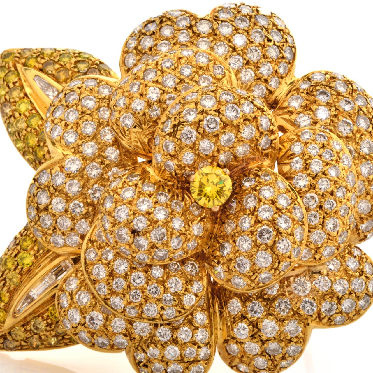 This breathtakingly beautiful estate brooch pin is handcrafted in solid 18K yellow gold. Showcasing a flower design, this piece centered with 1 genuine round cut fancy yellow diamond approx. 0.40 cttw, VS clarity prong set. It is pavé set with a