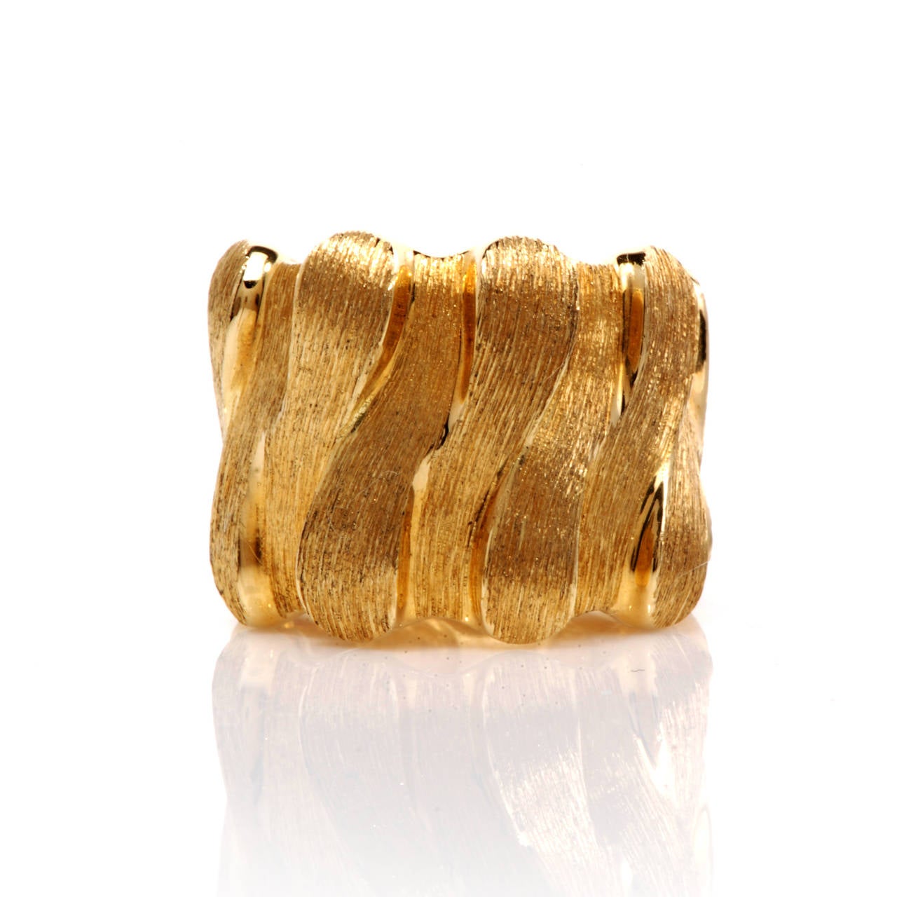 This stunning, 100% authentic saby Henry Dunay band ring is crafted in solid 18K gold. This ring is beautifully textured with a lovely overlapped style pattern design. This ring is signed and numbered and remains in NEW

Weight is approx: 16.0