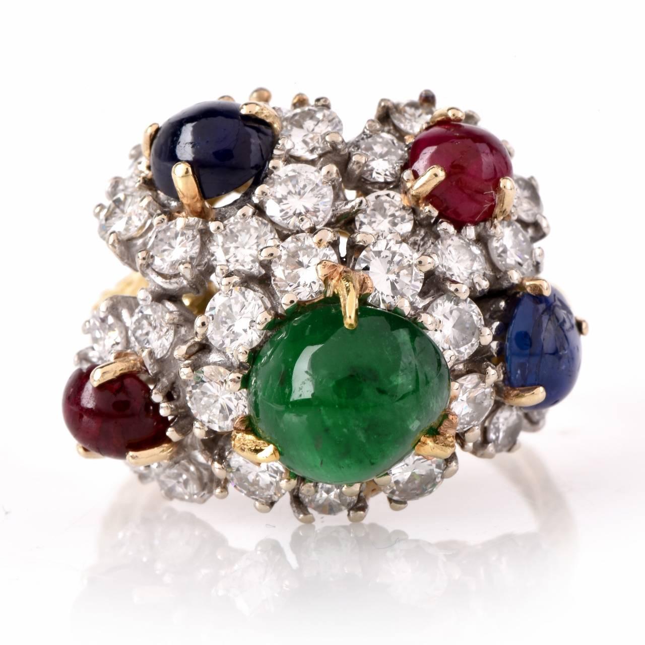 This  vintage cocktail ring with is crafted in 18K matte yellow gold, weighs 10.3 grams and measures 15mm wide and 10mm high. Designed as an assemblage of 5 graduated flowers, centered with emerald, sapphire and rub cabochons surrunded by  33