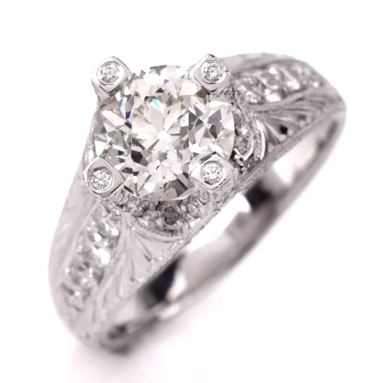 This gorgeous engagement shines with brilliance and sophistication. Finely crafted in solid platinum. It is centered with 1 genuine European-cut round diamond approx. 1.80t, I-J color, and VS1 clarity. Its mounting is set with 14 round diamonds