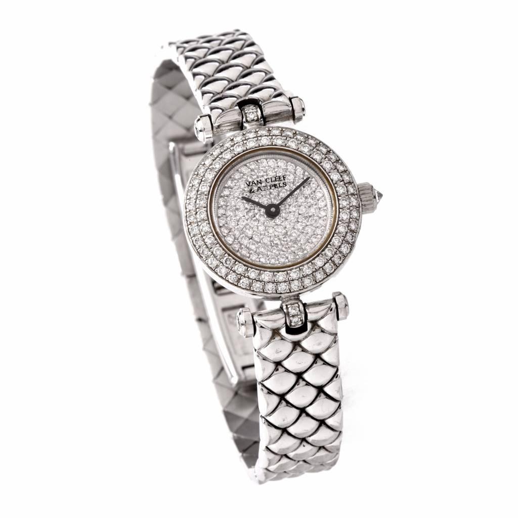 This classically distinct Van Cleef & Arpels ladies' watch is crafted in 18K white gold, featuring a 20 mm round case (not including crown), enriched with pave diamonds, a diamond-set white gold bezel bearing the designer's name, blue steel hands