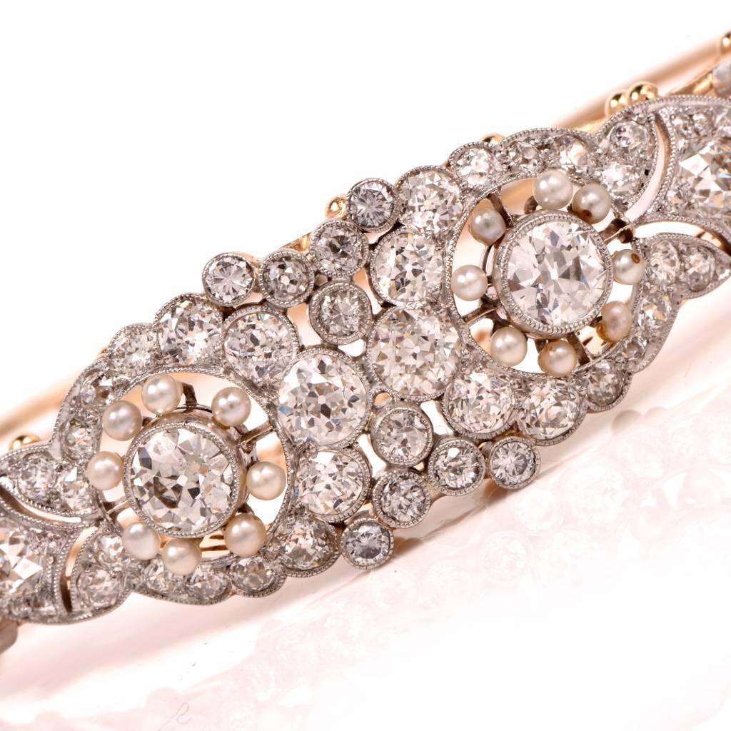 This vintage bangle bracelet is handcrafted in solid 14K yellow gold with solid platinum top. The bracelet incorporates a centrally positioned floral motif with two large round faceted european-cut diamonds approx. 1.28 carats total, G-H color,