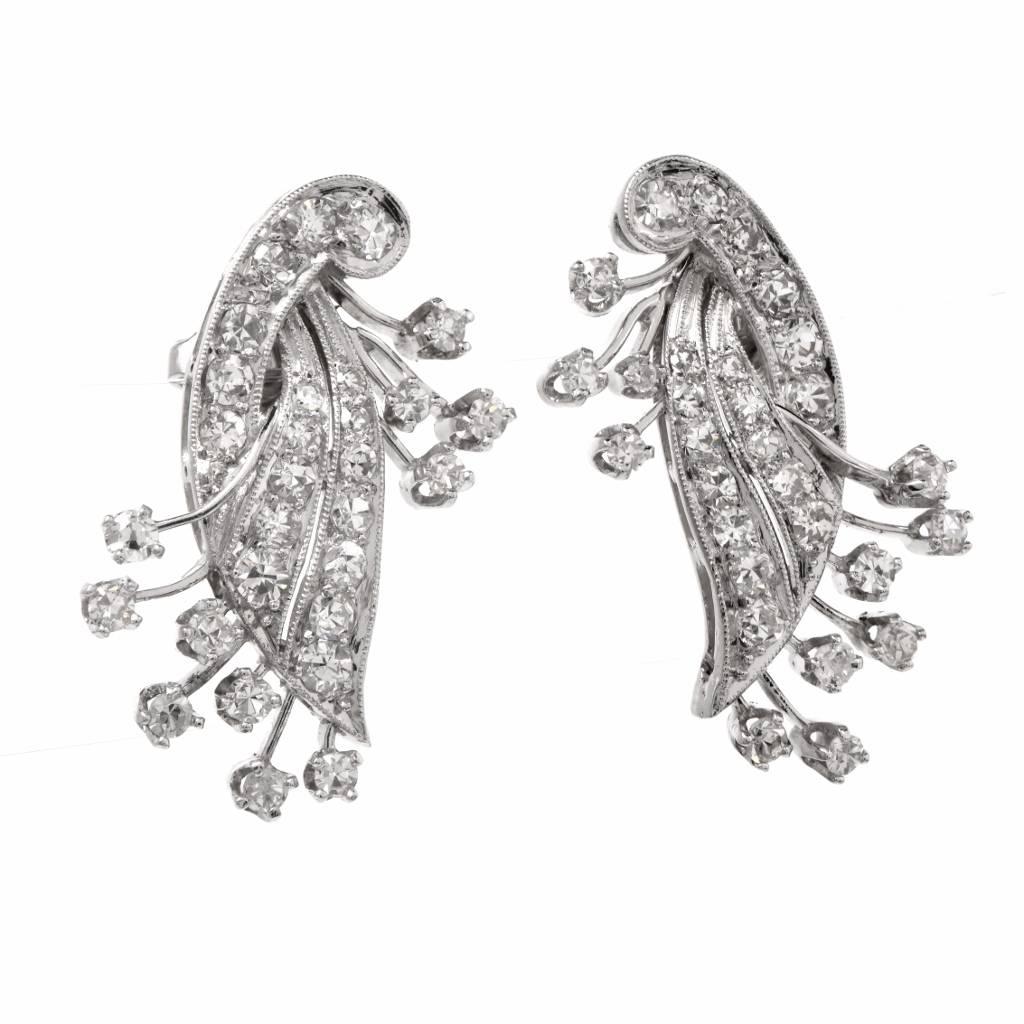 These vintage earrings of unmatched refinement are crafted in solid platinum, botanically inspired with floral sprays and diamond buds on finely mille grained stems. The earrings are cumulatively adorned with approx. 50 genuine round-faceted
