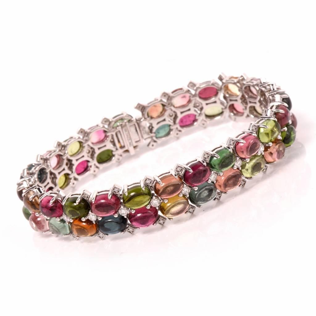 This vividly colored vintage link bracelet crafted in solid 18K white gold is adorned with a colorful palette of 48 oval cabochon gemstones, weighing cumulatively 50.28 cts, complemented by 72 genuine round-faceted diamonds, cumulatively weighing