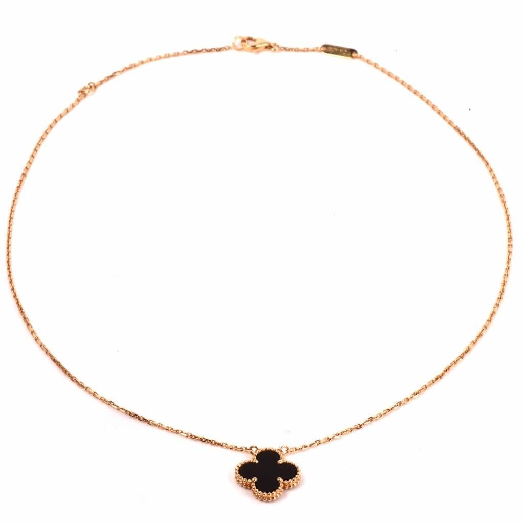 This authentic Van Cleef & Arpels pendant necklace from the 'Alhambra' collection depicts an elegant dual face black onyx clover motif pendant with granulated contour, and an 18K yellow gold integrated chain. The alhambra collection with the iconic