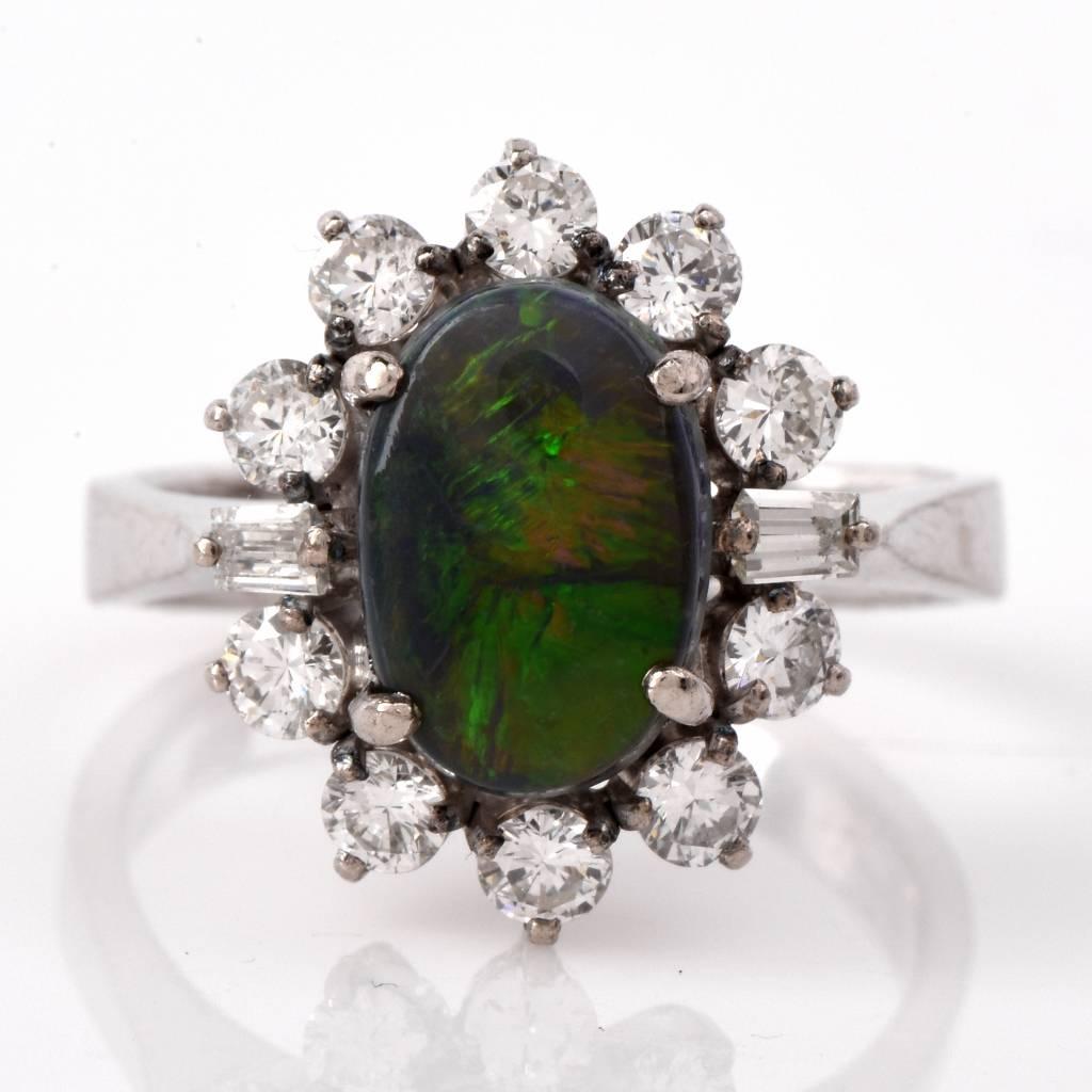 This captivating estate cocktail ring with an opal cabochon and diamonds is crafted in solid 14K white gold. Incorporating an aesthetically enchanting ovular plaque, it is centered with an eye-catching fine opal oval cabochon, weighing 2.23cts. This