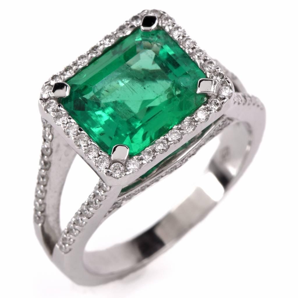 This magnificent Emerald diamond ring is crafted in 18K white gold. Centered with one genuine intense transparent green Emerald with minor natural  inclusions of approx: 3.97cttw. Adorned by some 82 round cut genuine diamonds approx: 1.05cttw, F-G