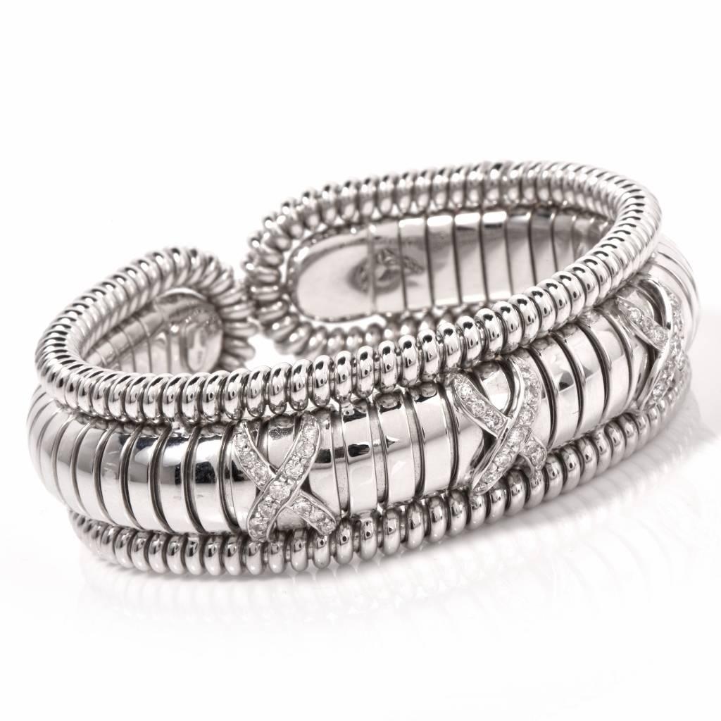 This high polish Italian cuff bracelet of opulent aesthetic is crafted in solid 18K polished white gold weighing approx. 90.1 grams and measuring approx. 20mm wide. This well designed cuff bracelet features ornate twisted wire perimeters and rounded