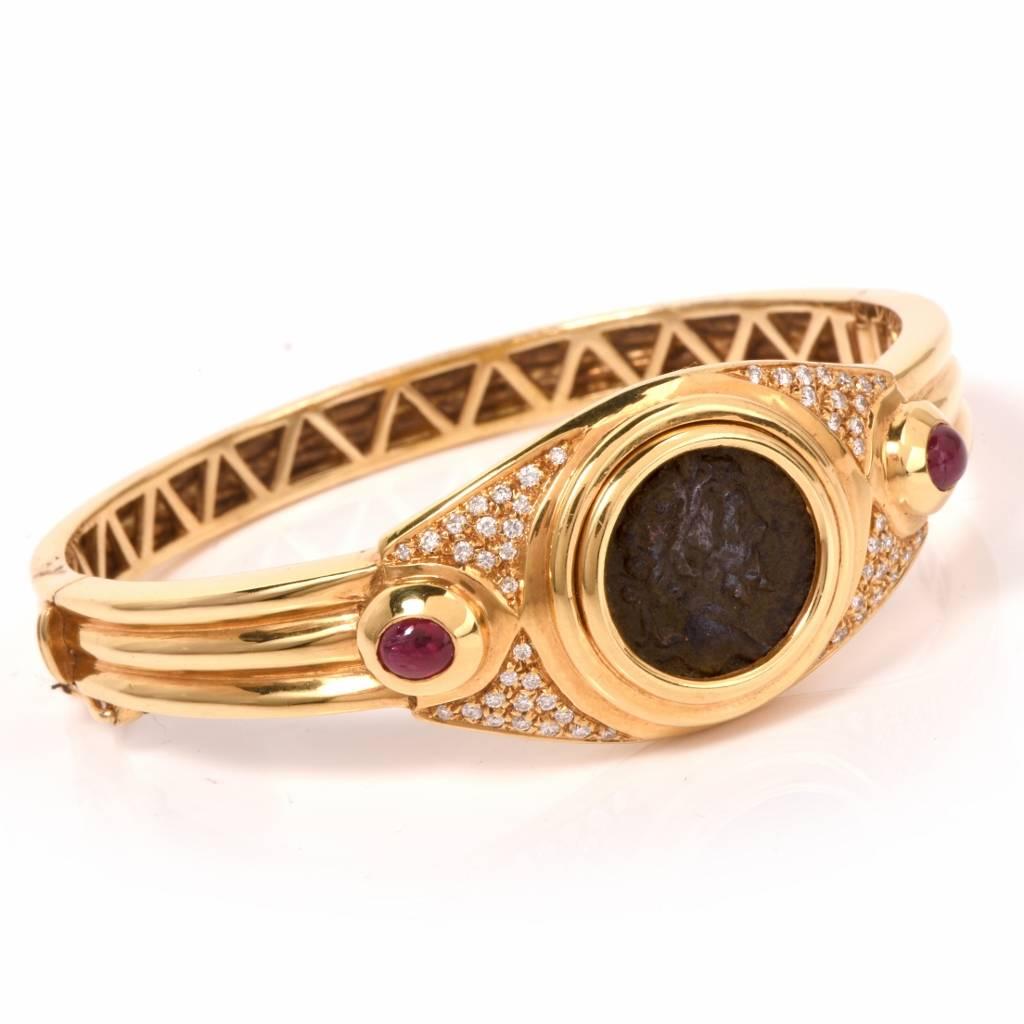 This estate Italian bangle bracelet is crafted in solid 18K yellow gold. The  ancient Roman coin design is complemented by two ruby cabochons of approx. 0.90ct. The colorful corundum are surrounded by 48 pave-set diamonds weighing approx. 0.80ct