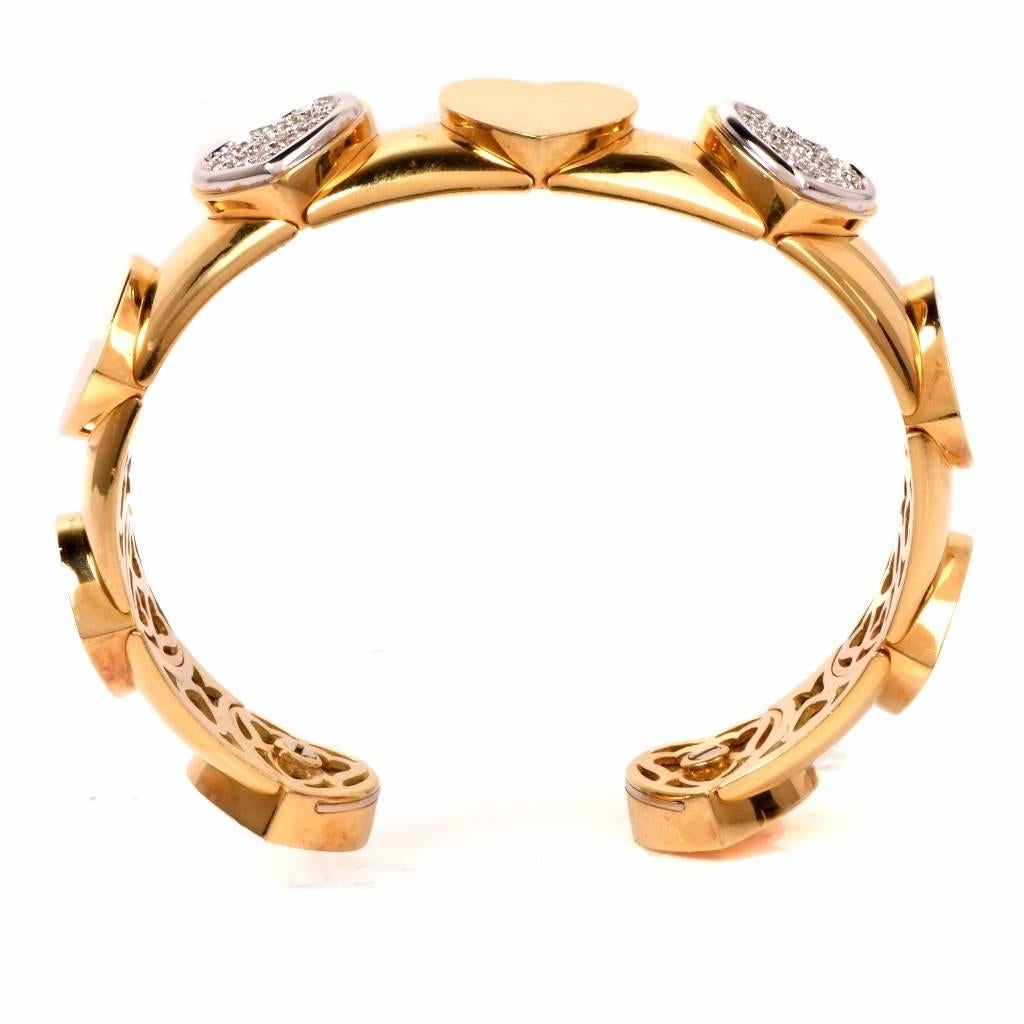 This romantically designed bangle cuff bracelet with heart profiles is crafted in solid 18K yellow gold. The bracelet weighs approx. 46.8 grams and measures 6.1/4