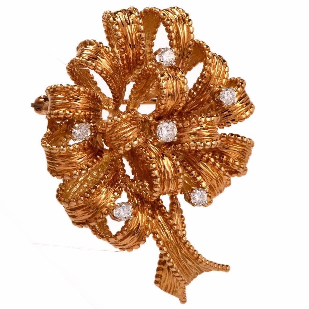 This floral brooch is designed by the New York designer Henry Dankner, crafted in solid 18K textured yellow gold simulating fine ribbon converted into beautiful flower. The artfully rendered brooch is adorned with 6 high quality diamonds