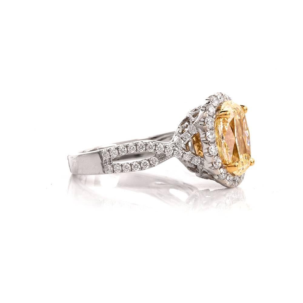 This diamond engagement ring in halo design is crafted in solid 18K white gold. This engagement ring is centered with a GIA CERTIFIED approx, 2.93cts oval cut diamond of natural fancy light yellow color, SI1 clarity (small inclusions not visible to